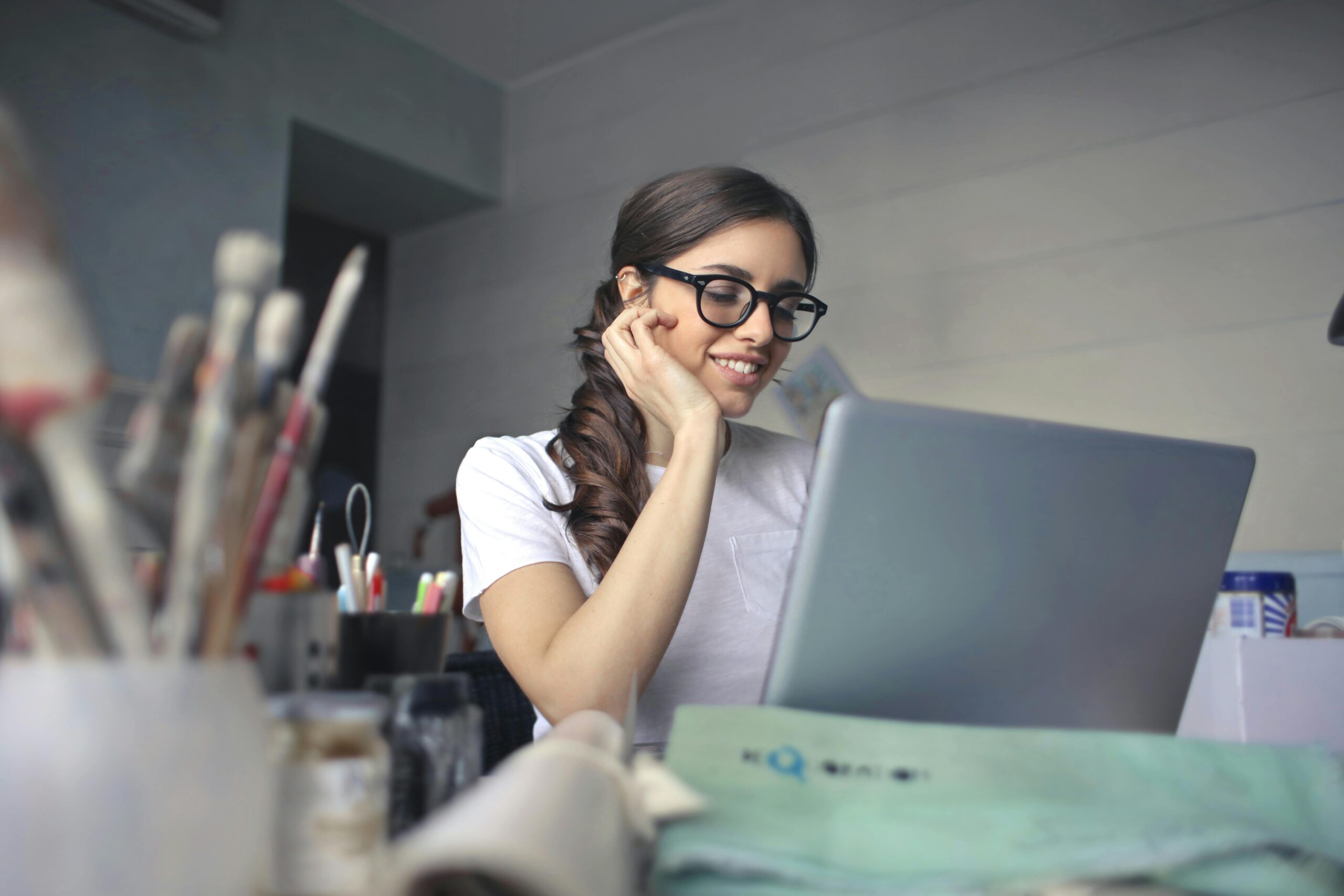 Creative professional working remotely in an artistic home office, focused on laptop