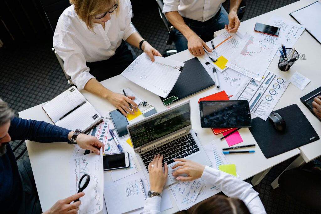 Colleagues collaborating at a busy communal work desk